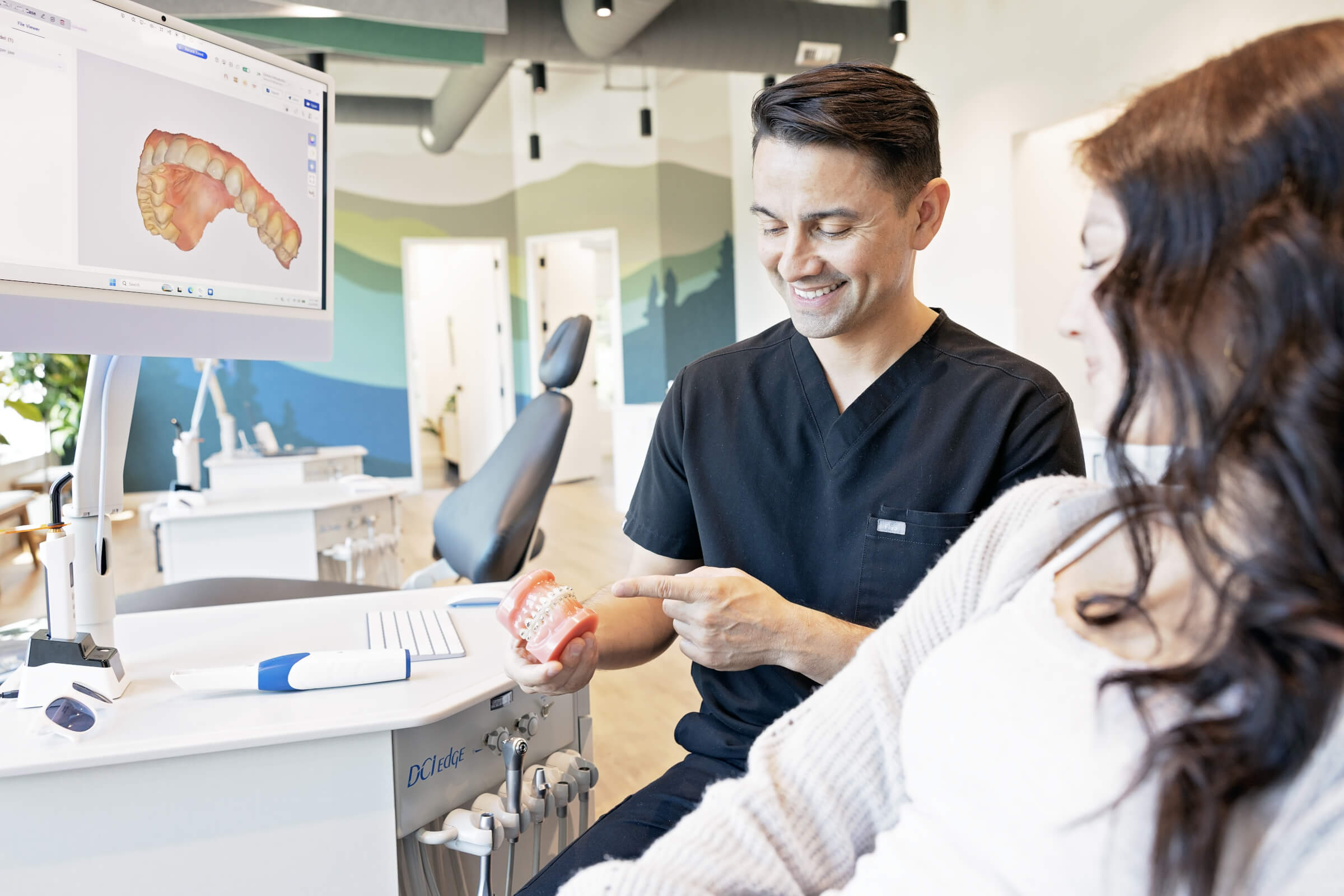 doctor with orthodontic model talking to patient